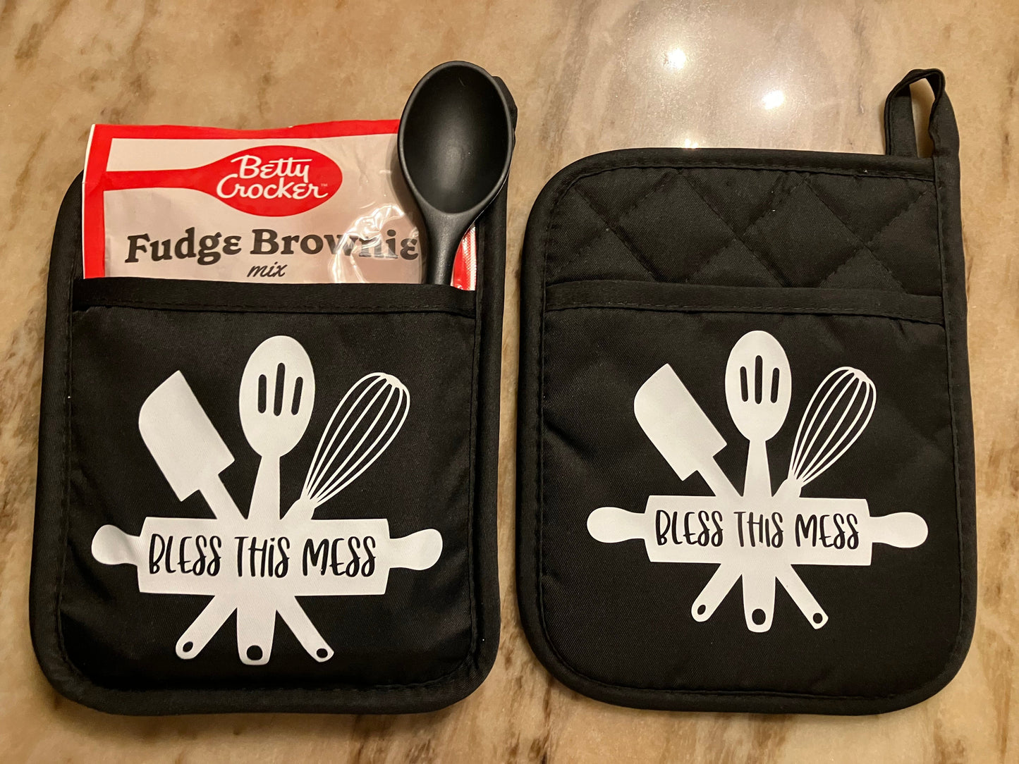 Bless This Mess Gift Set with Message in White on 2 Black Pot Holders, 1 Dessert Mix, 1 Spatula or Spoon.